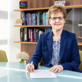 Prof Andrea Nolan sitting at a desk in front of a bookcase